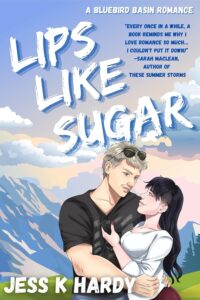 Illustrated cover with a mountain background with some snow but also some green and blue sunny skies. In the foreground and slightly to the right, is a good looking older white couple embracing. He has a black v-neck tee on and has gray short but slightly shaggy hair and is wearing aviator sunglasses on his head. She has dark long hair with bangs and shaved bits above her ears. She is built and is wearing a white long sleeved tee. He is facing the front and she is side on in his arms and they are smiling at each other.